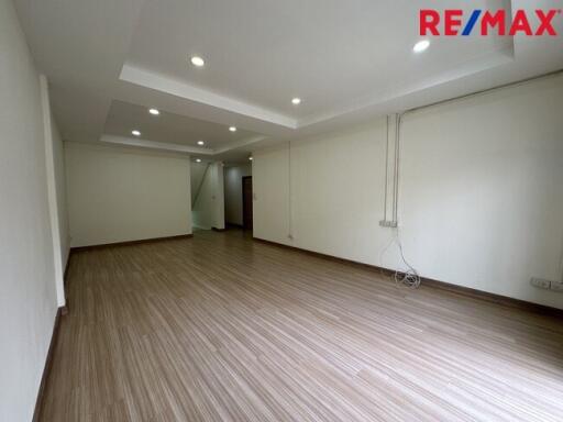 Spacious unfurnished living area with wooden flooring and recessed lighting