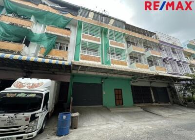 Exterior view of a commercial or residential building with multiple floors and a truck parked in front