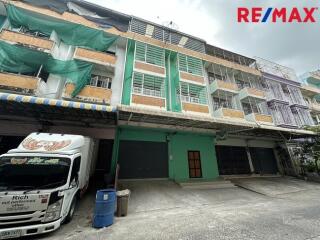 Exterior view of a commercial or residential building with multiple floors and a truck parked in front