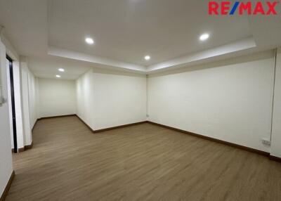 Spacious empty room with wooden flooring and recessed lighting