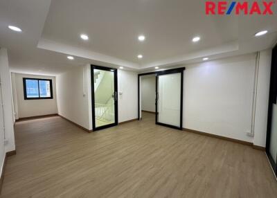 Spacious main living area with wooden flooring and large windows