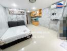 Bright studio with bed, kitchenette, and wall-mounted air conditioner