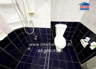 Bathroom with dark blue tiles and white fixtures