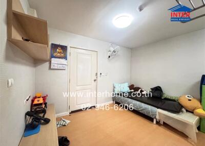 Bedroom with single bed, wall-mounted shelves, calendar, ceiling light, and children