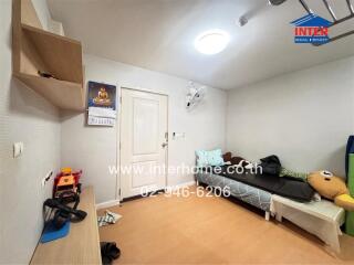 Bedroom with single bed, wall-mounted shelves, calendar, ceiling light, and children
