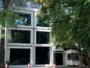 Modern multi-story building surrounded by trees