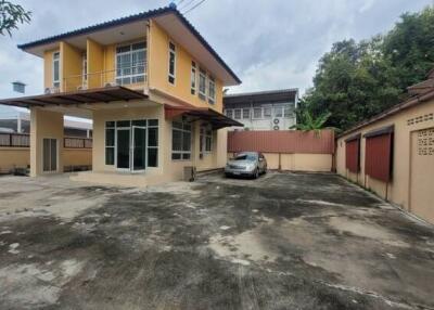 Exterior view of a two-story house with driveway and car