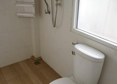 Bathroom with toilet, window, and shower