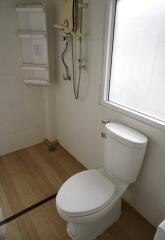 Bathroom with toilet, window, and shower