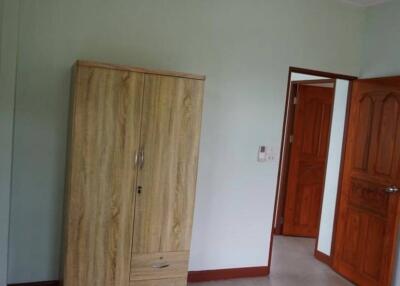 Bedroom with wooden wardrobe and partially open door