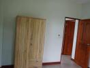 Bedroom with wooden wardrobe and partially open door