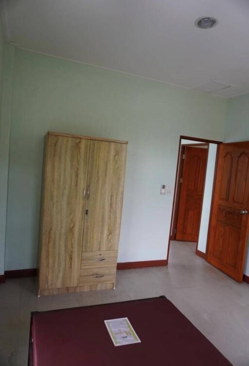 Bedroom with wooden wardrobe and partially open door