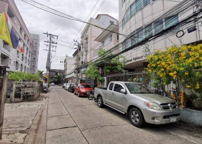 Street view with multiple buildings and parked cars