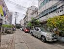 Street view with multiple buildings and parked cars