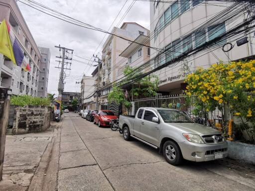 Street view with multiple buildings and parked cars
