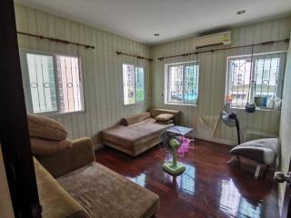 Cozy living room with multiple seating options and wooden flooring