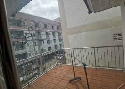 Outdoor balcony space with a partial view of surrounding buildings