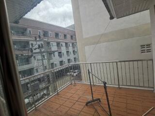 Outdoor balcony space with a partial view of surrounding buildings