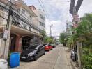 Street view with cars parked and residential buildings