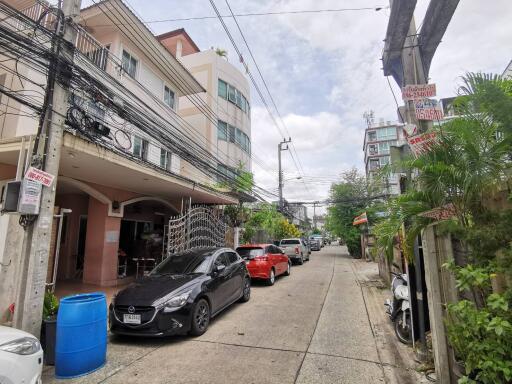 Street view with cars parked and residential buildings