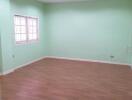Empty living room with wooden floors and green painted walls