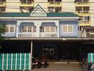 Two-story blue building with teal roof and white accents