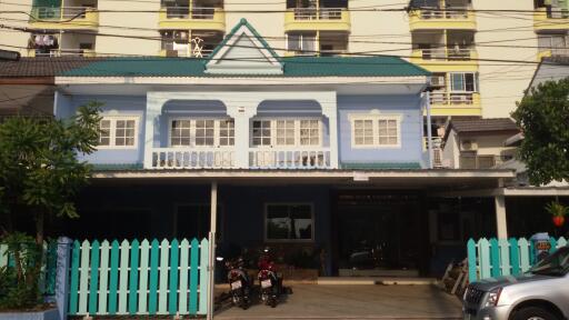 Two-story blue building with teal roof and white accents