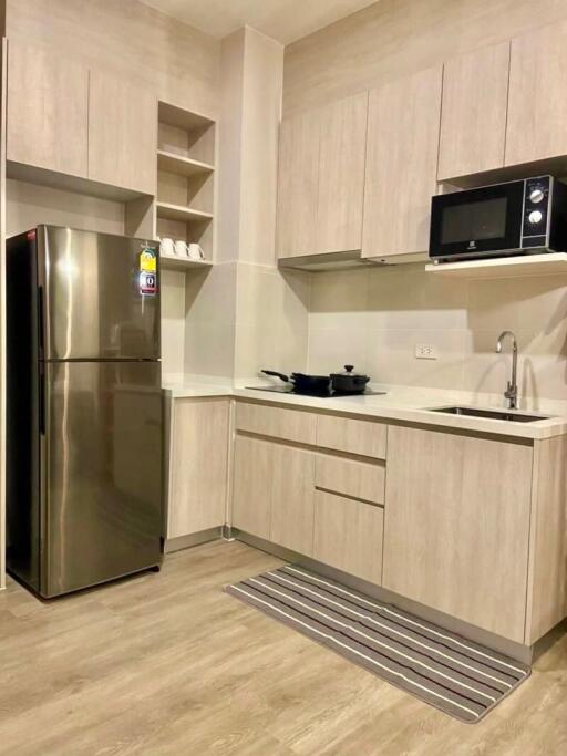 Modern kitchen with stainless steel refrigerator, microwave, and ample cabinetry