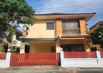 Exterior view of a two-story house with a red fence