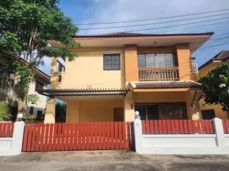 Exterior view of a two-story house with a red fence