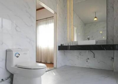 Modern bathroom with white marble tiles and floating vanity