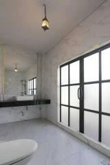 Modern bathroom with large frosted glass windows, a suspended sink, and a toilet.