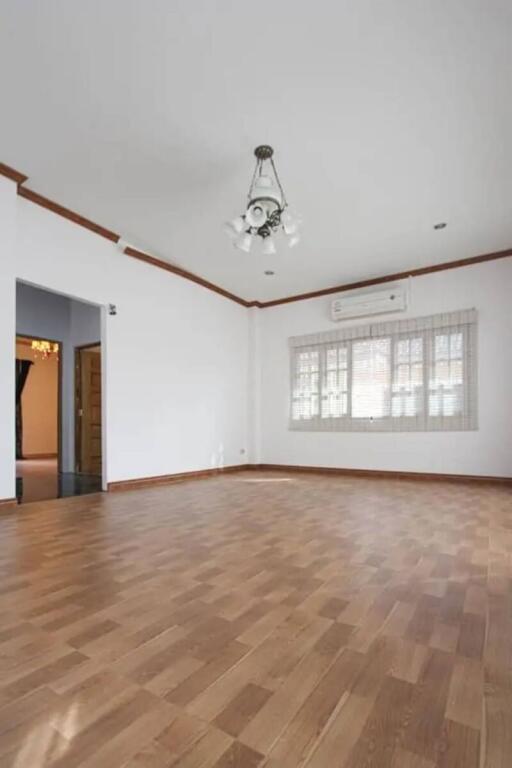 Spacious living room with hardwood floor and large window