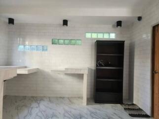 Laundry room with tiled walls and shelving