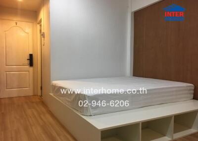 Bedroom with wooden flooring, a white bedframe, and a wooden accent wall