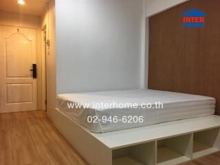 Bedroom with wooden flooring, a white bedframe, and a wooden accent wall