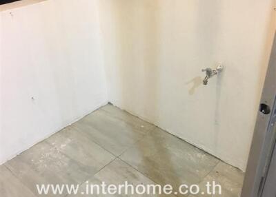 Empty bathroom space with incomplete wall and floor tiling