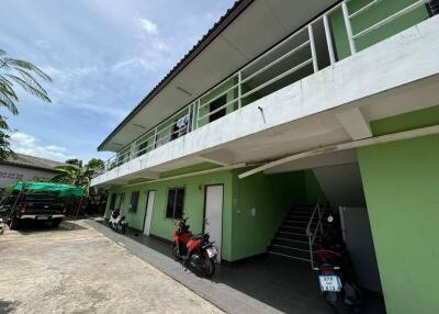 Exterior view of a two-story residential building with parked motorcycles