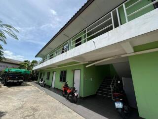 Exterior view of a two-story residential building with parked motorcycles