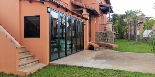 Residential building exterior with glass doors and lawn