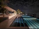 Night view of a rooftop pool with seating area and cityscape