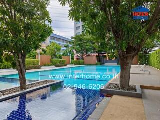 Outdoor swimming pool area with trees and seating