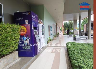 Outdoor view of a building with ATM and green plants