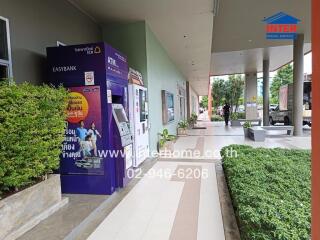 Outdoor view of a building with ATM and green plants