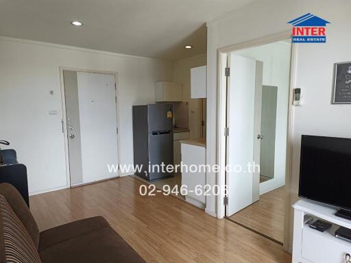 Living room with adjacent kitchen and labeled contact details for the real estate agency