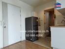 Small kitchen with white cabinets, a stainless steel fridge, and wooden flooring