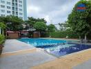 Modern outdoor swimming pool with surrounding greenery and adjacent building