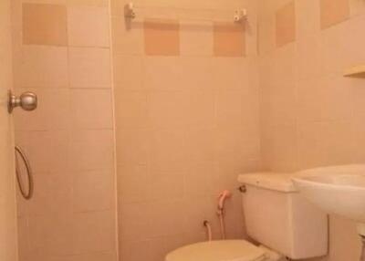 Bathroom with beige tiles, toilet, and sink