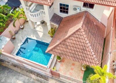 Aerial view of a house with a tiled roof and a swimming pool