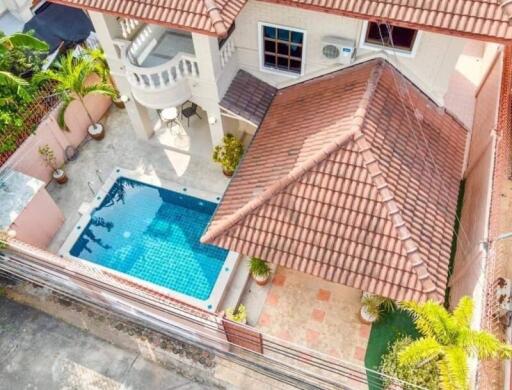 Aerial view of a house with a tiled roof and a swimming pool